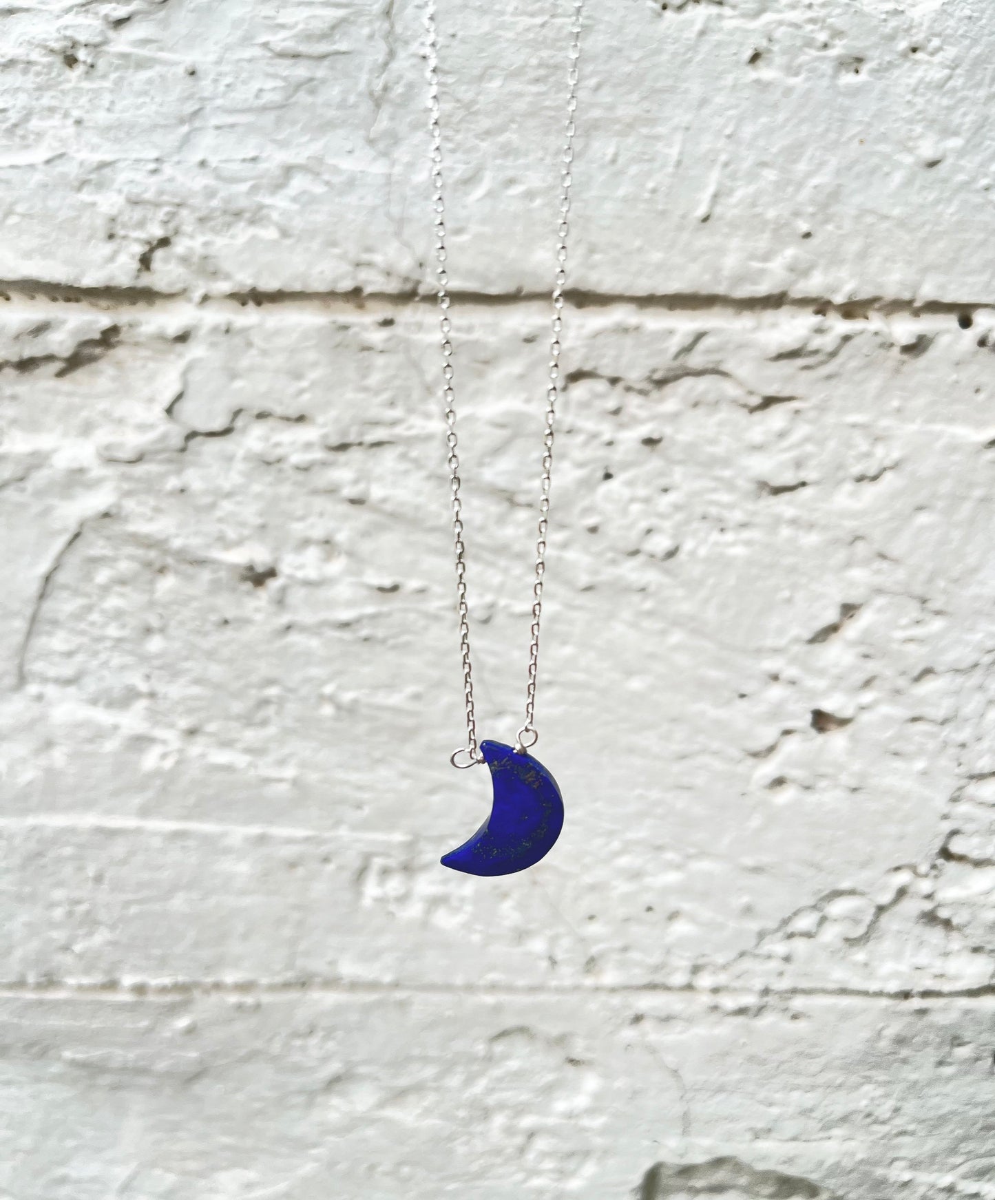 Half moon lapis lazuli necklace with a deep blue crescent shaped stone