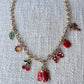 gold charm necklace with lady bug, apple, butterfly, flower, leaf, palm tree