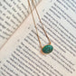 Malachite evil eye necklace featuring a green and black eye-shaped charm on a dainty gold chain